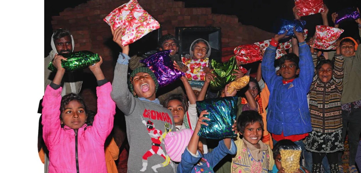 Voller Freude strecken diese pakistanischen Kinder ihre Weihnachtsgeschenke in die Höhe (csi)